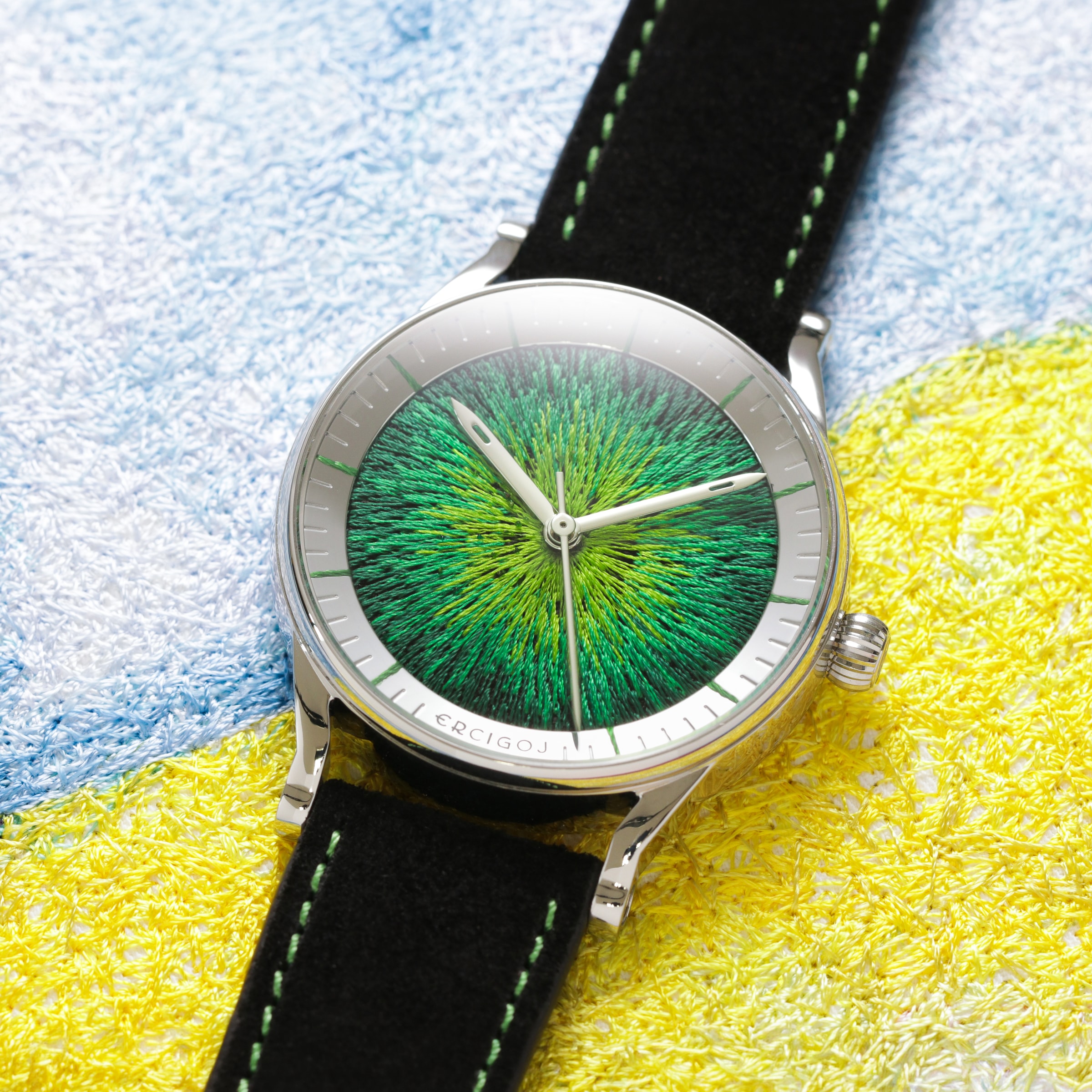 JACQUARD with a round steel case and an emerald green embroidered dial, on a black suede strap with green stitching