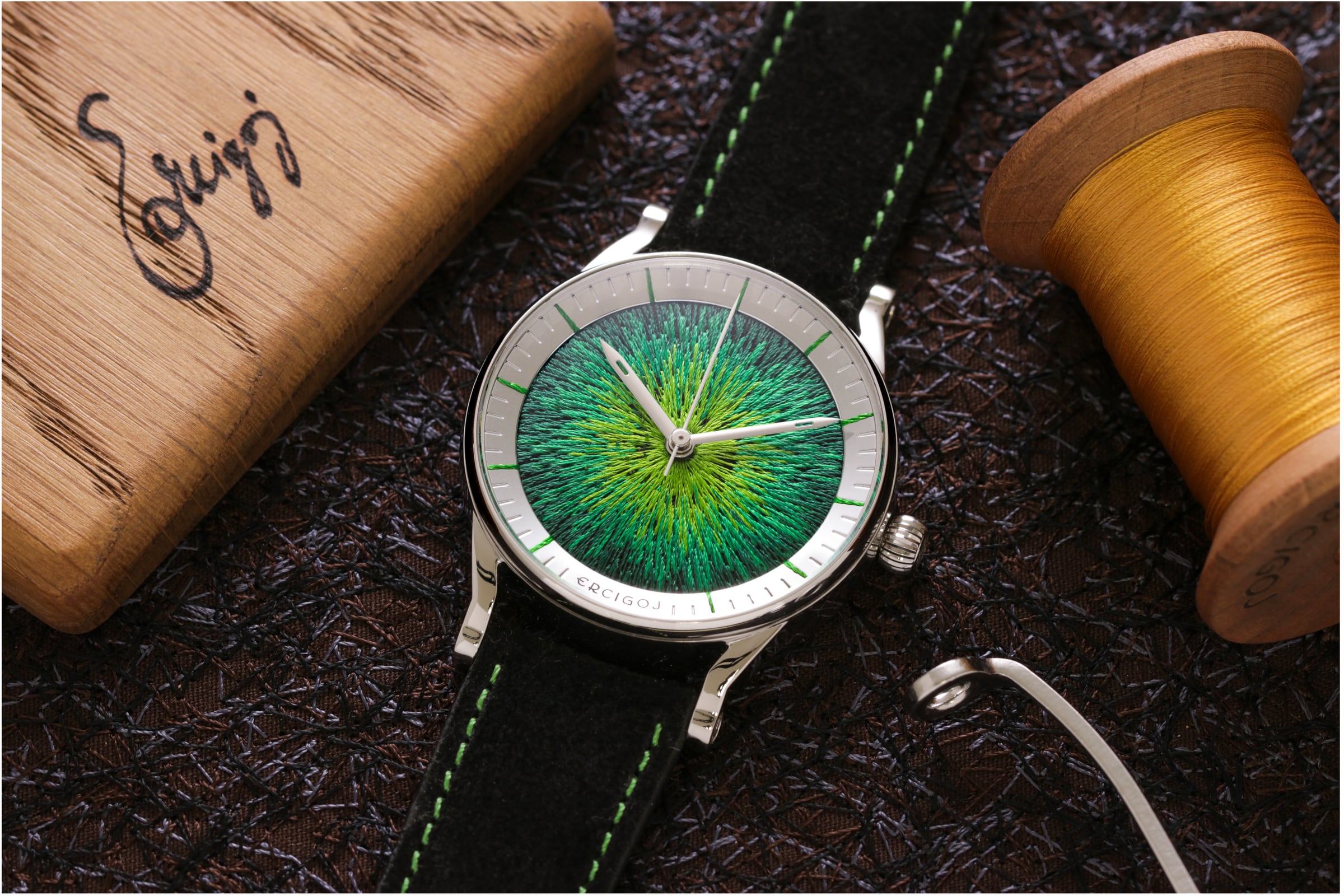 JACQUARD with a round steel case and an emerald green embroidered dial, on a black suede strap with green stitching